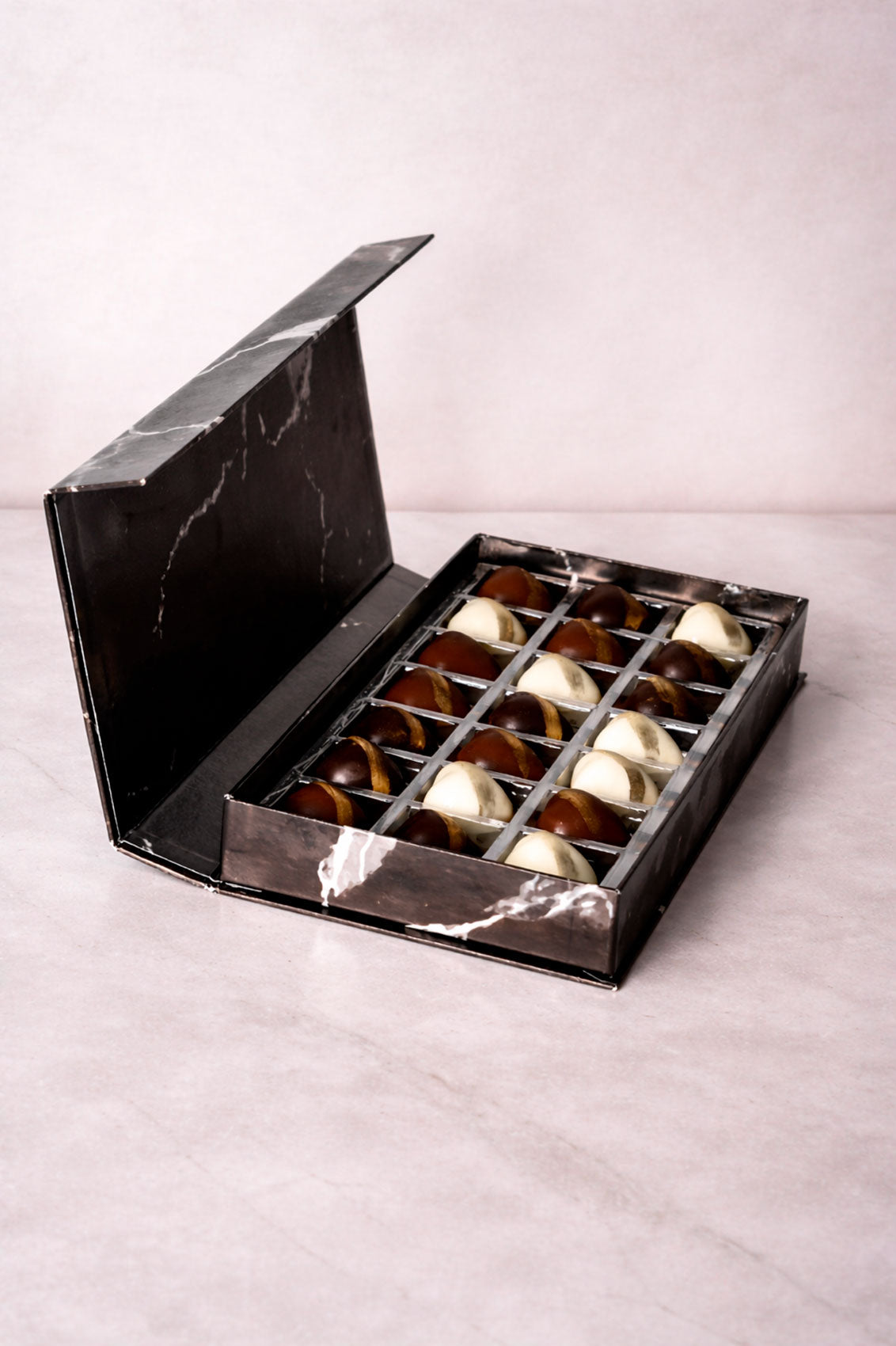 Caja Negra 21 Citas de Chocolates Rellenos de Pistache y Kataifi Estilo Dubai sobre fondo marmol
