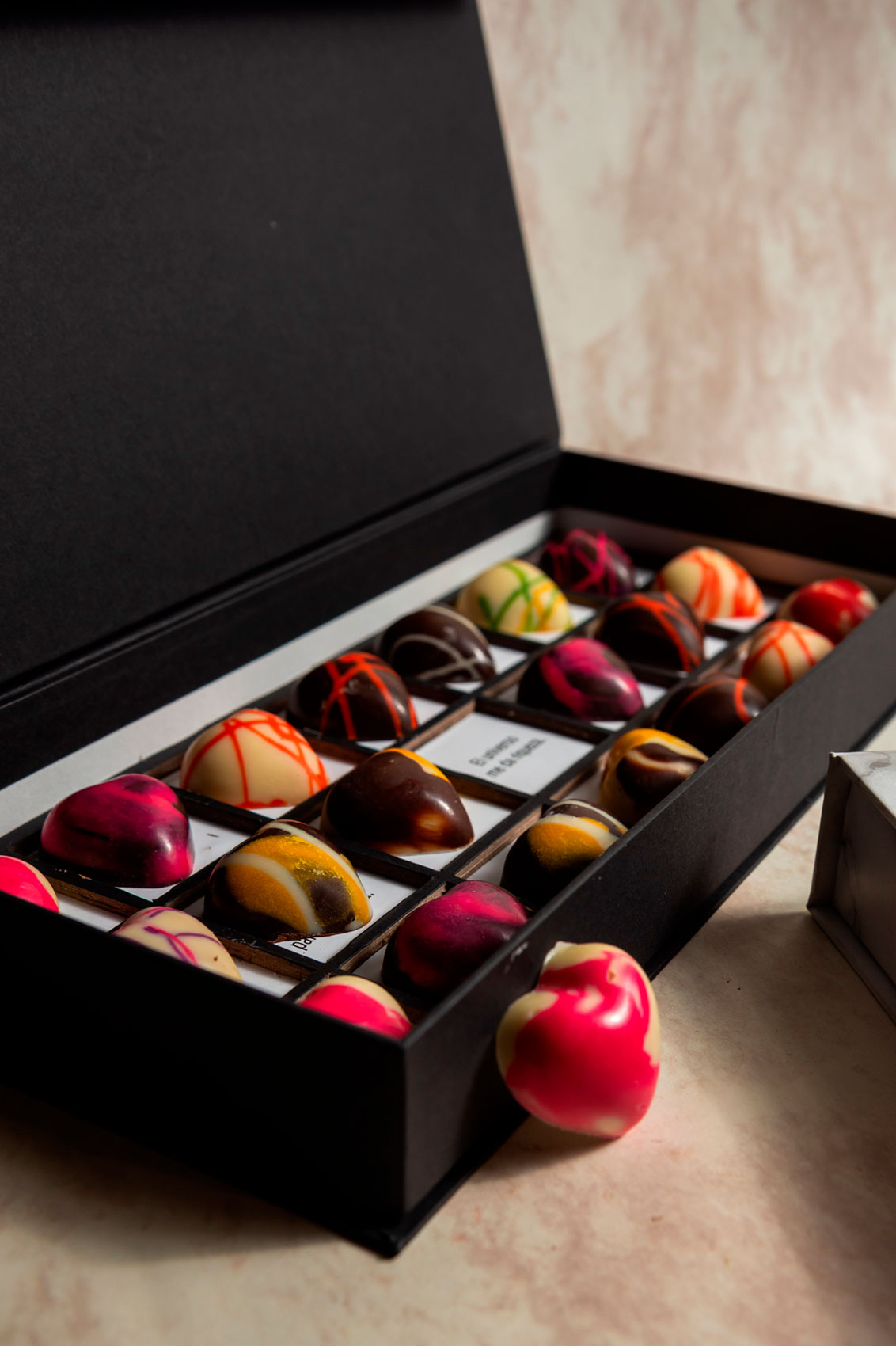 Caja Negra de Chocolates 21 Citas para Parejas Relleno Frutal y Cacao Mexicano Fondo Marmol