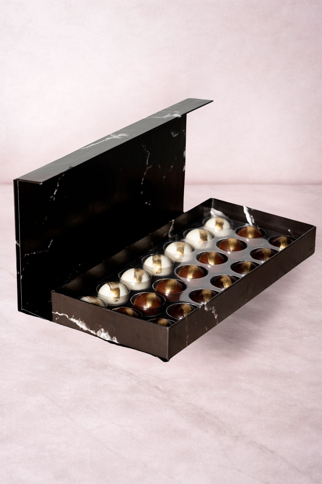 Caja Negra de 21 Chocolates Días Positivos Relleno Dubai con Pistache y Kataifi Fondo Marmol