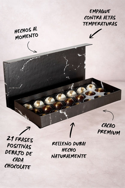 Caja Negra de 21 Chocolates Días Positivos Relleno Dubai con Pistache y Kataifi Fondo de Marmol