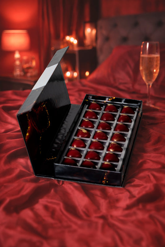 Caja Negra de Chocolates Afrodisíacos 21 Tentaciones Regalo Premium Chocolate Belga Sobre una Cama de Sabanas Rojas