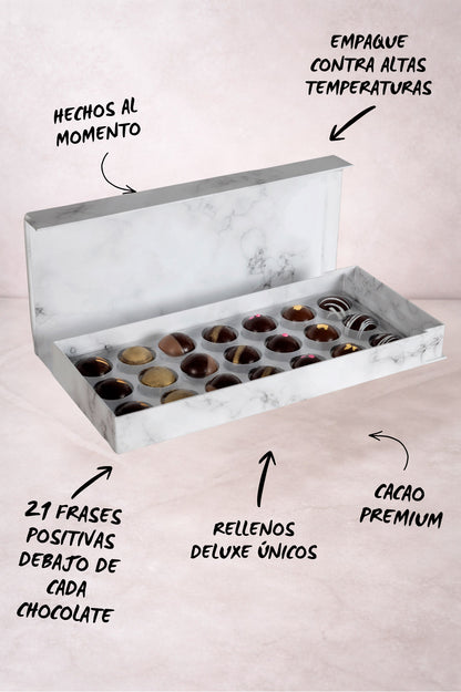Caja de chocolates negros abiertos de la marca ChocoRoux con 21 piezas rellenas y diseño premium sobre fondo mármol.