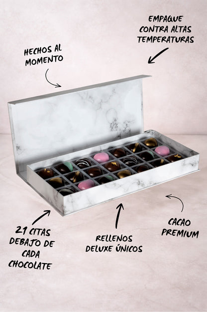 Caja blanca de chocolates negros abiertos de la marca ChocoRoux con 21 piezas rellenas y diseño premium sobre fondo mármol.
