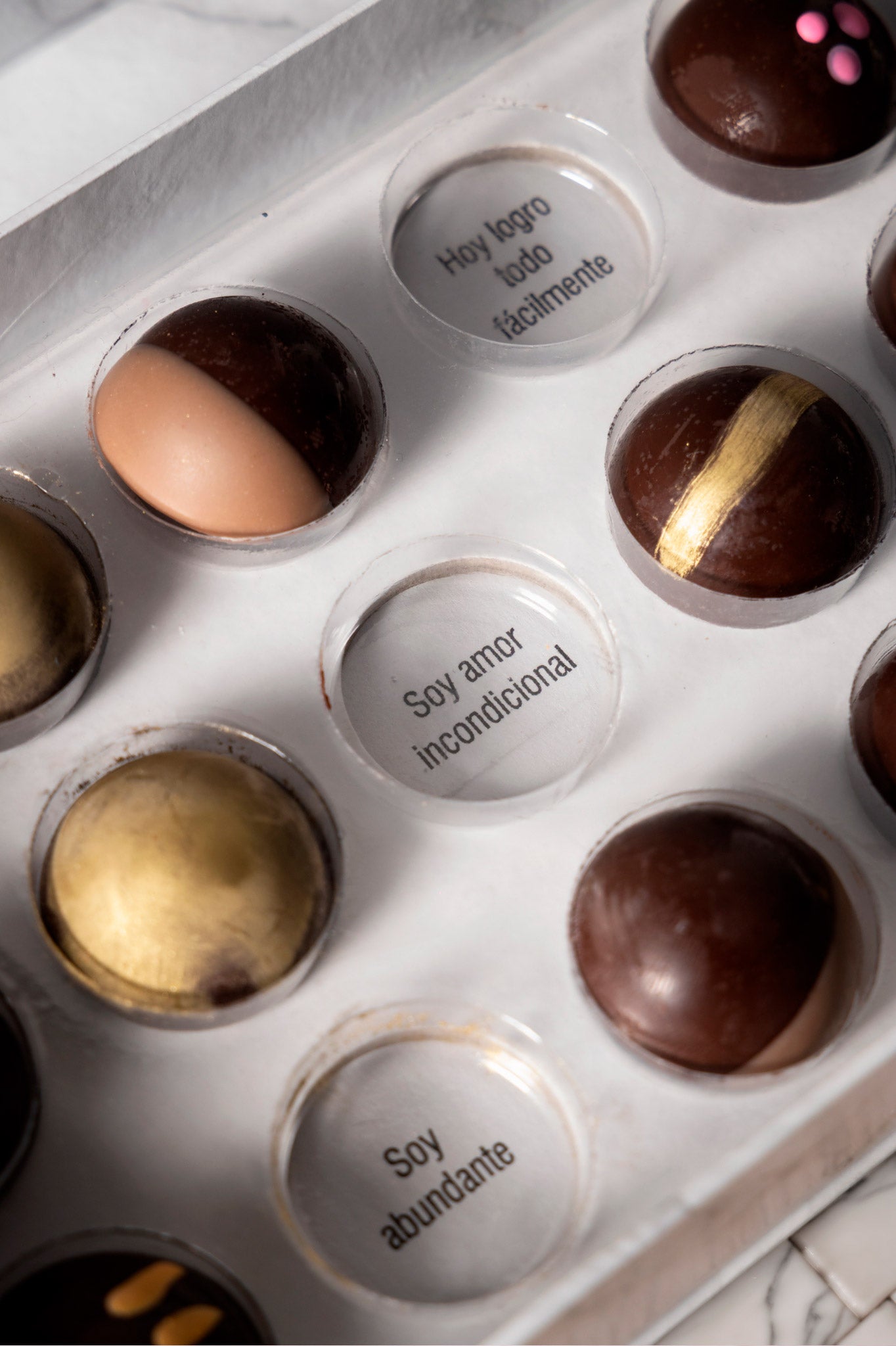 Caja de chocolates negros abiertos de la marca ChocoRoux con 21 piezas rellenas y diseño premium sobre fondo mármol.