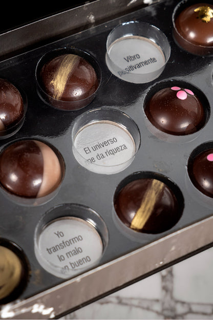 Caja de chocolates negros abiertos de la marca ChocoRoux con 21 piezas rellenas y diseño premium sobre fondo mármol.