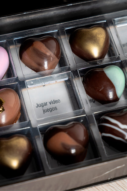 Caja de chocolates negros abiertos de la marca ChocoRoux con 21 piezas rellenas y diseño premium sobre fondo mármol.