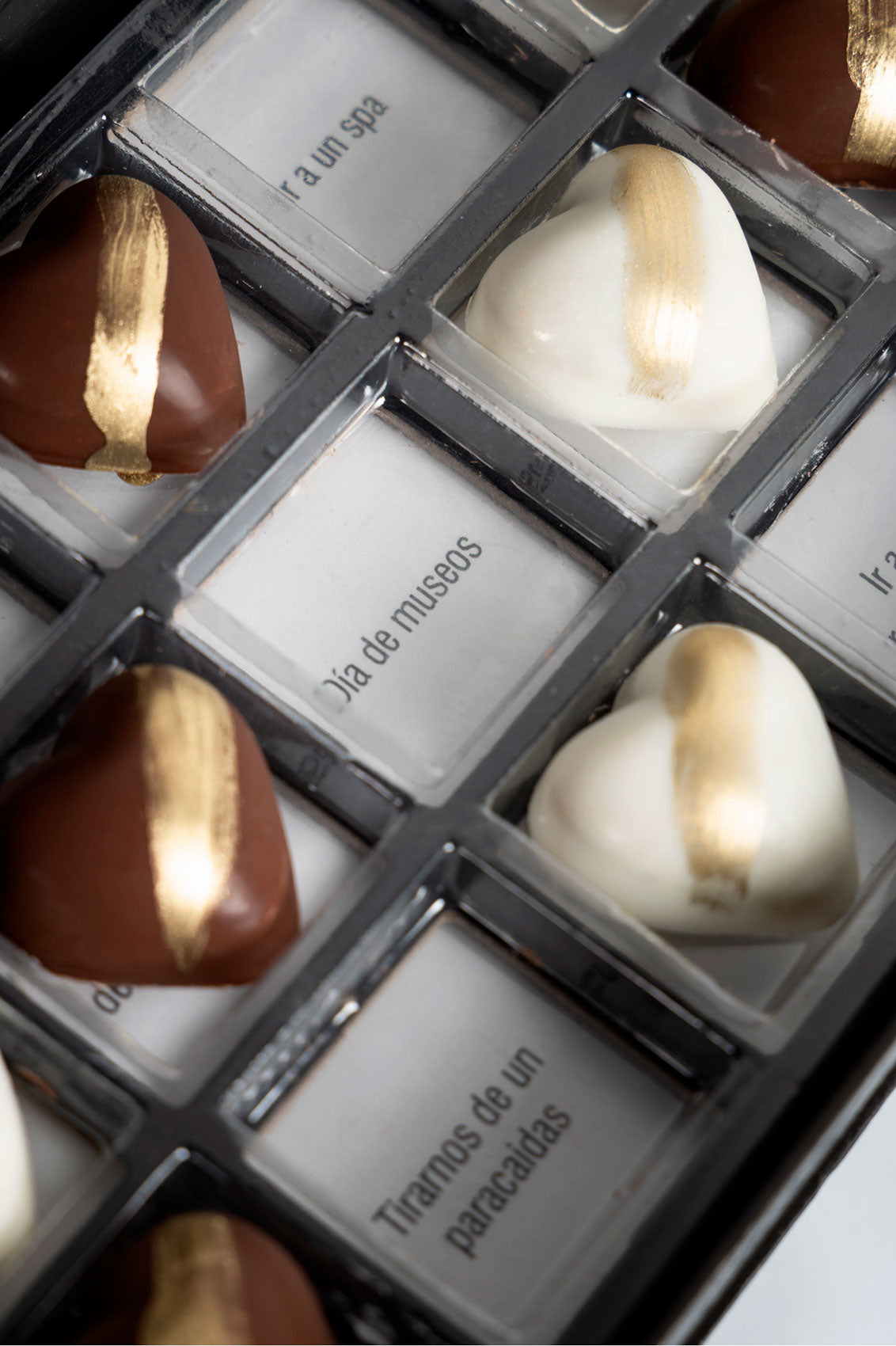 Caja negra 21 Citas de Chocolates Rellenos de Pistache y Kataifi Estilo Dubai fondo marmol con frases visibles