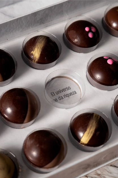 Caja de chocolates negros abiertos de la marca ChocoRoux con 21 piezas rellenas y diseño premium sobre fondo mármol.