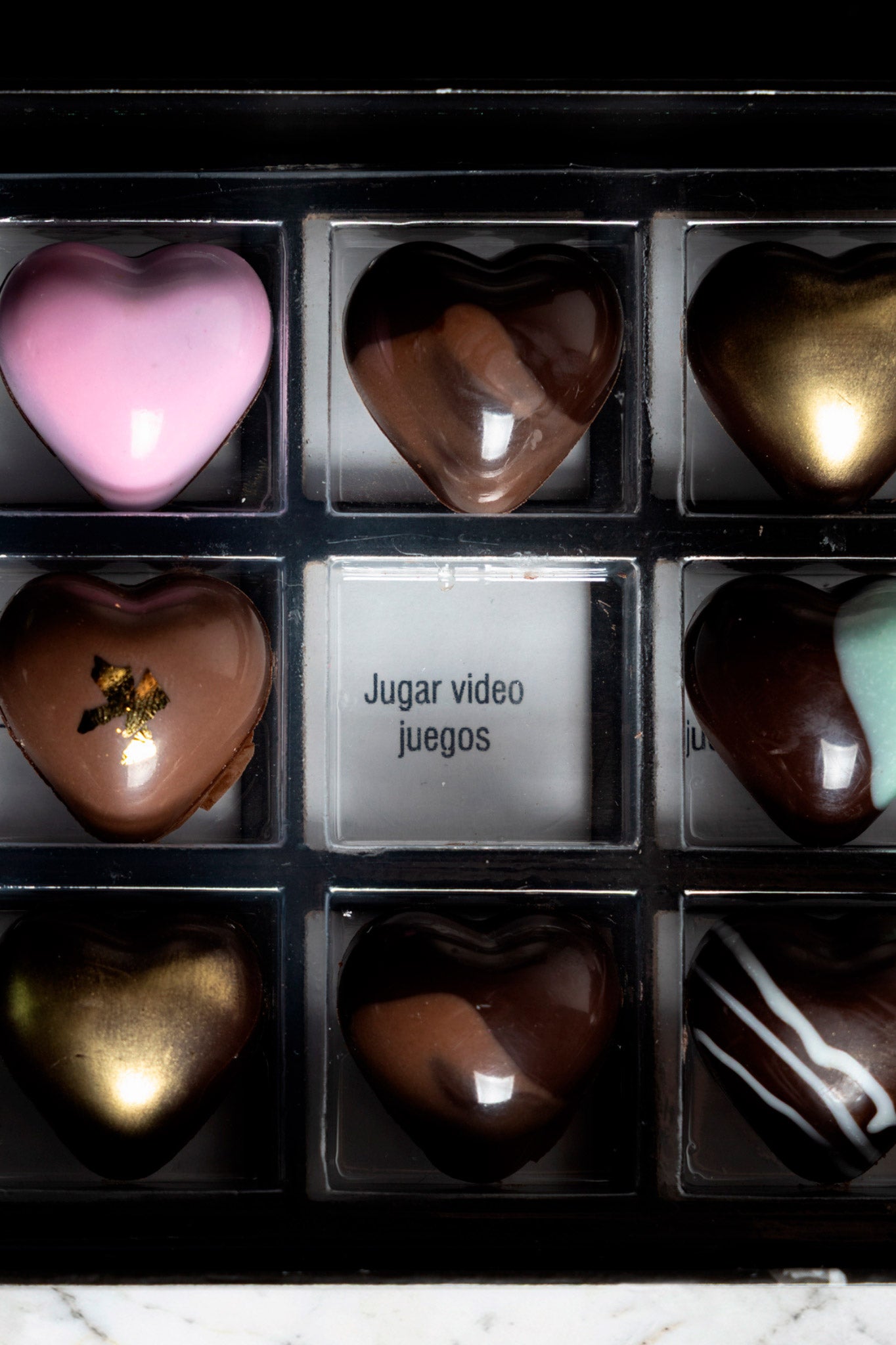 Caja de chocolates negros abiertos de la marca ChocoRoux con 21 piezas rellenas y diseño premium sobre fondo mármol.