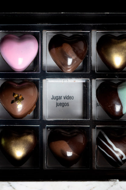 Caja de chocolates negros abiertos de la marca ChocoRoux con 21 piezas rellenas y diseño premium sobre fondo mármol.