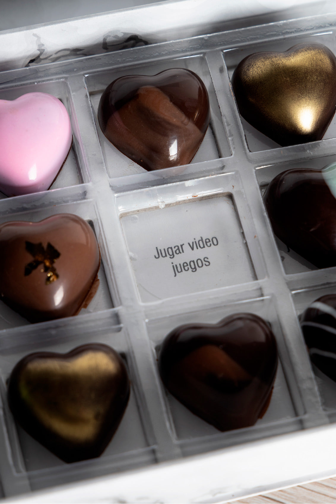 Caja blanca de chocolates negros abiertos de la marca ChocoRoux con 21 piezas rellenas y diseño premium sobre fondo mármol.