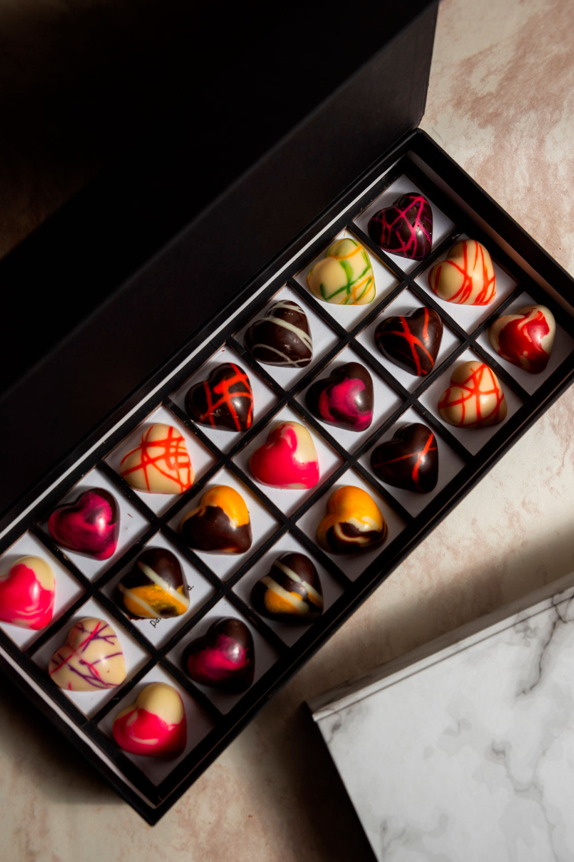 Caja Negra de Chocolates 21 Citas para Parejas Relleno Frutal y Cacao Mexicano Fondo Marmol