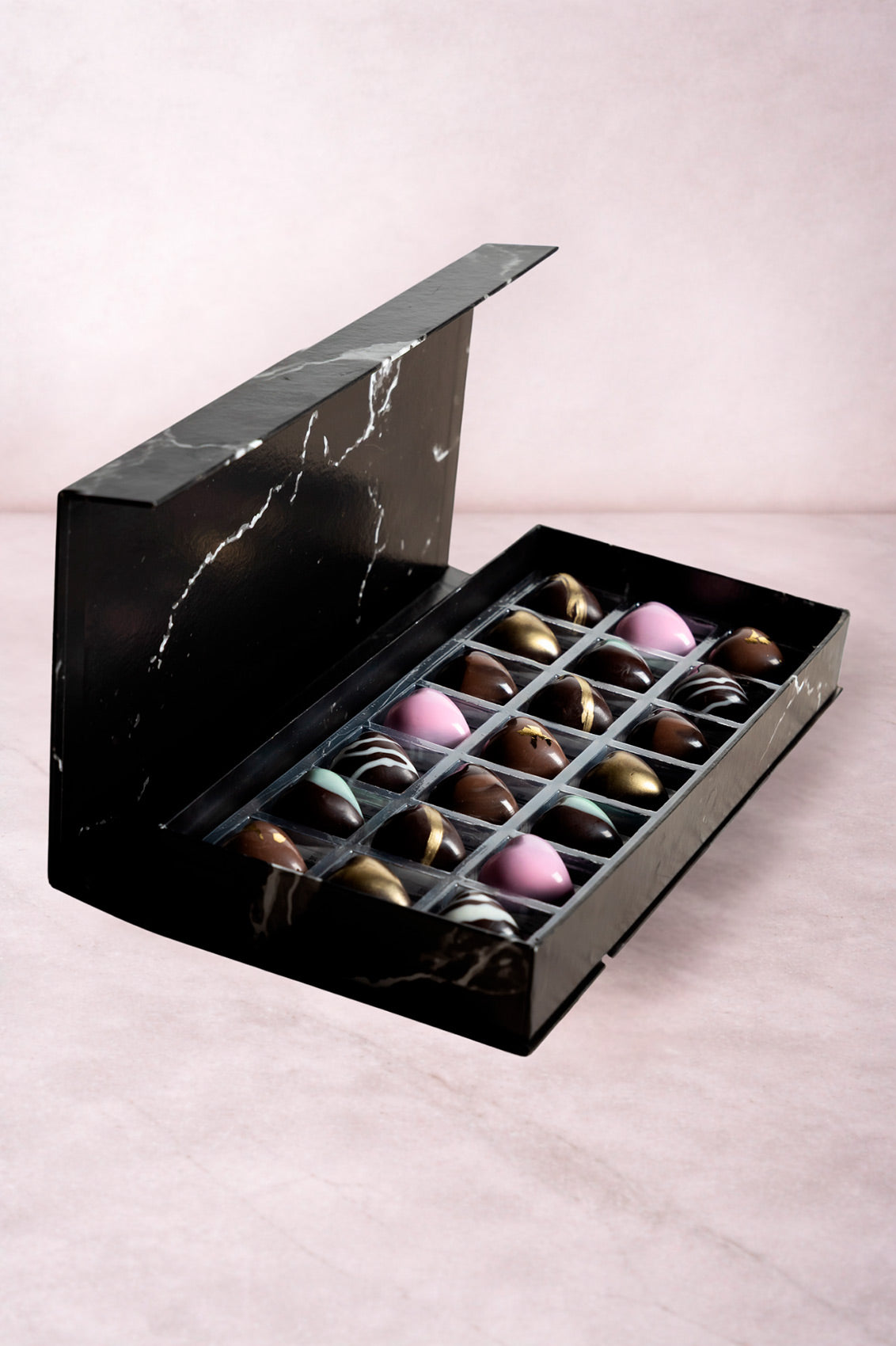 Caja de chocolates negros abiertos de la marca ChocoRoux con 21 piezas rellenas y diseño premium sobre fondo mármol.